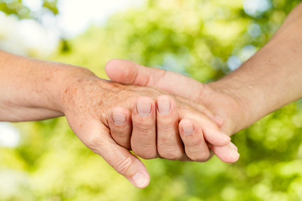 Closeup of old people hands holding together outdoors