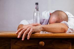 man passed out with liquor bottle - opioids