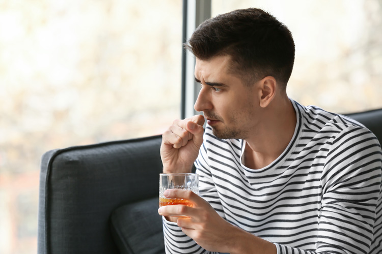 young man holding alcoholic drink about to cough - immune system