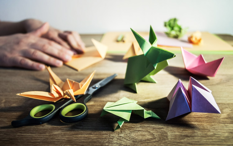 Origami crafts and supplies on wooden table - creativity