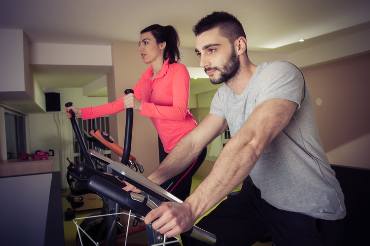 man and woman each on a cardio workout machine - exercise and mood